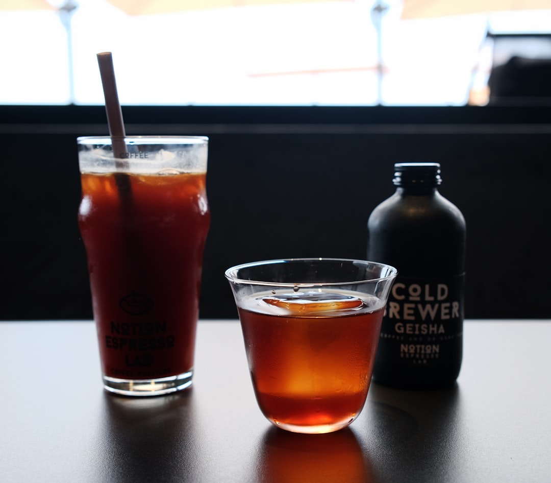 A table with a drink and a bottle on it