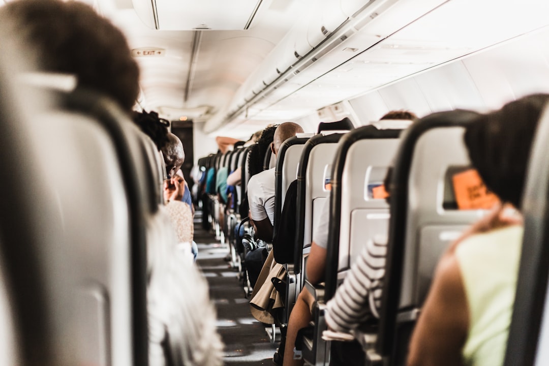 ネックピローを使って飛行機で快眠する旅行者